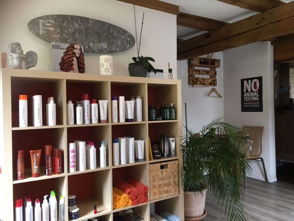 Friseursalon mit hochqualitativen Haarpflegeprodukten im Regal und gemütlicher Einrichtung