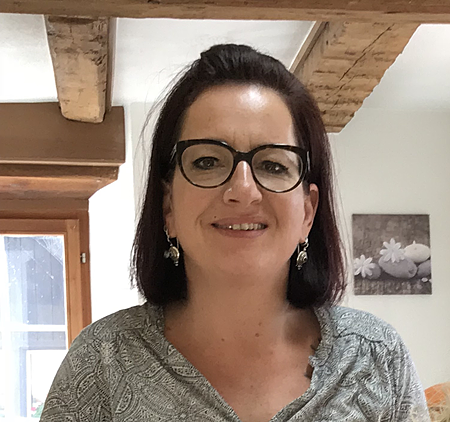 Freundliche Frau, Ihre Friseurin, mit Brille in einem hellen Raum